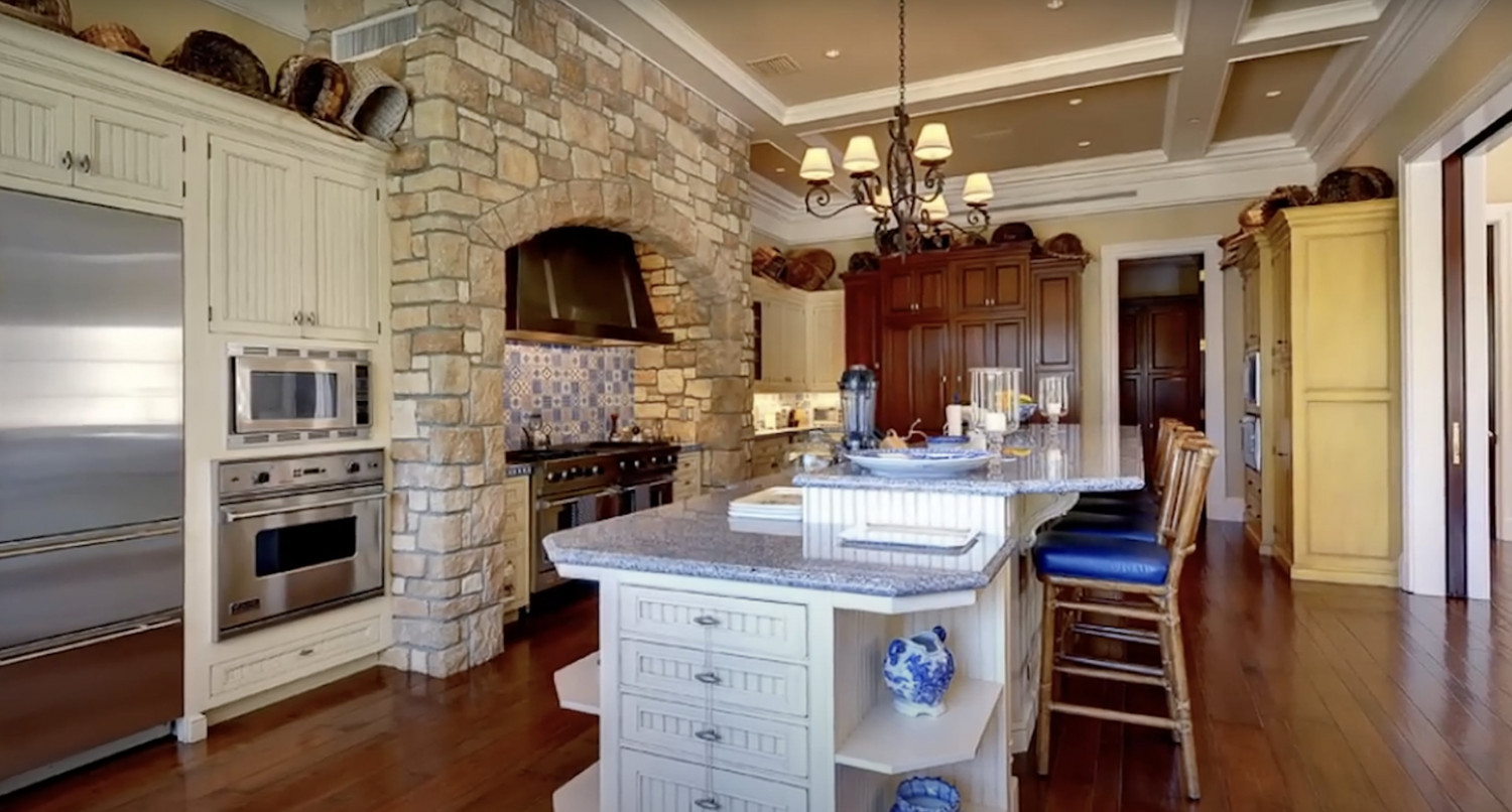 Gourmet chef's kitchen with stone accents, oversized island, and custom cabinetry in a luxury Bel Air estate.