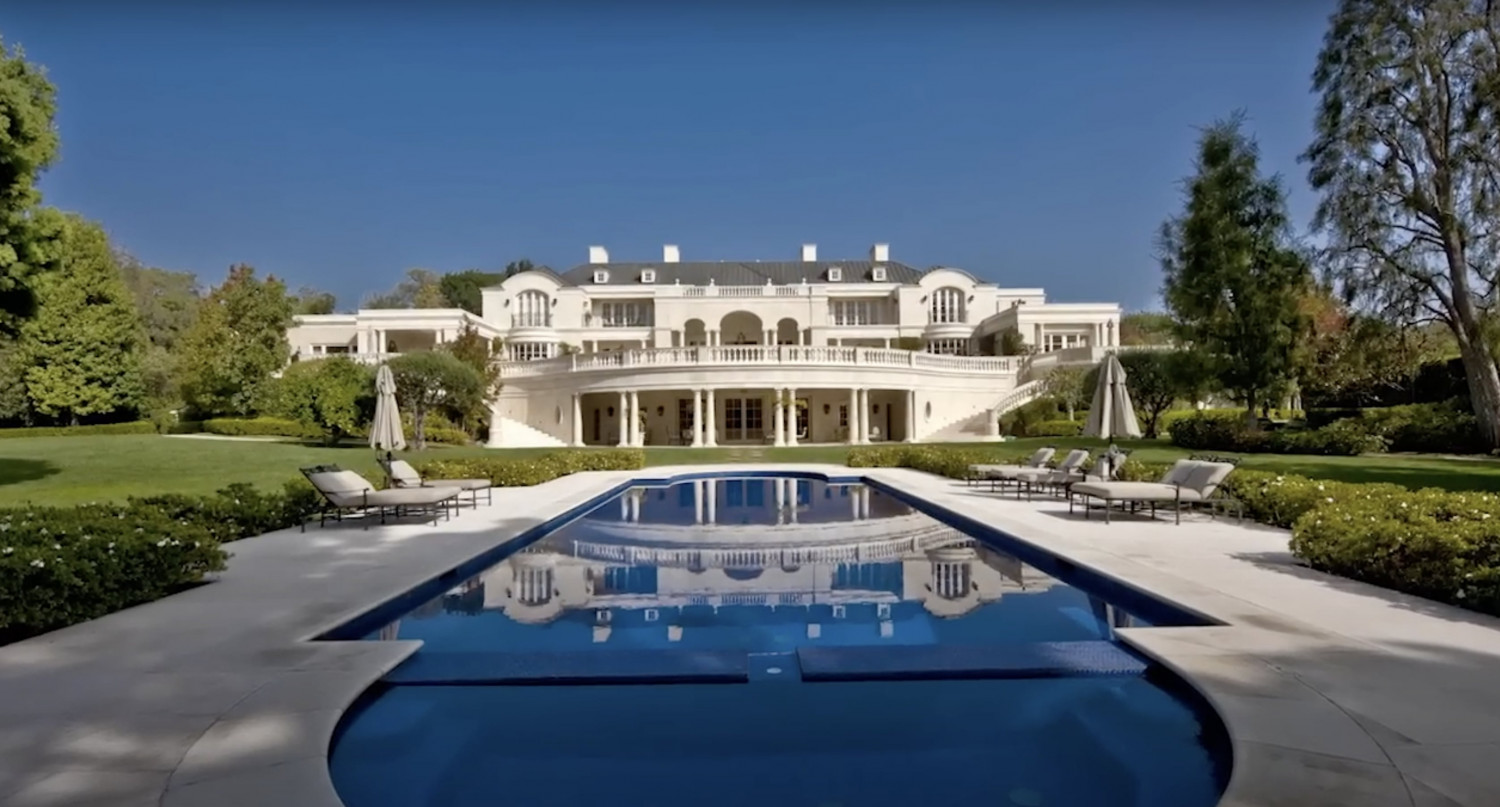 Resort-style swimming pool overlooking the rear façade of a luxury Bel Air estate with expansive lawns.